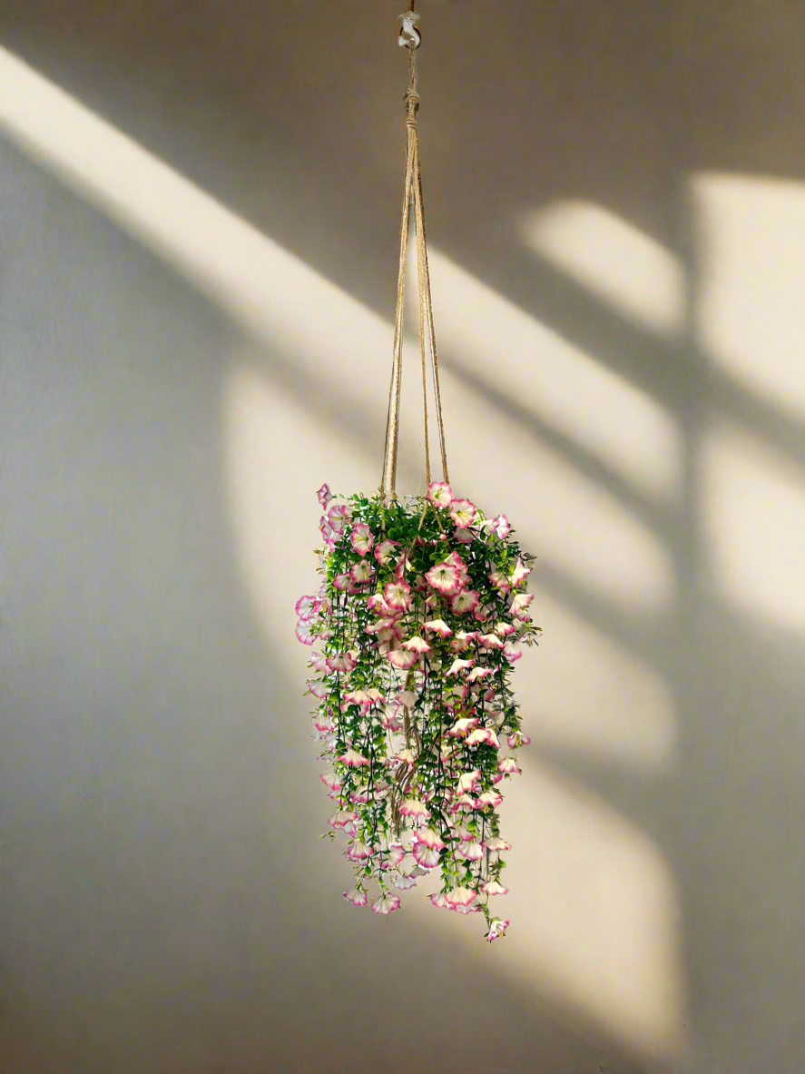 Hanging artificial flowers with purple tips and greenery